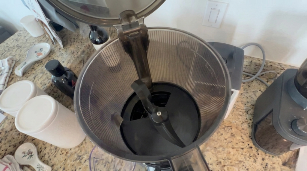 close-up view of the automatic feeding hopper on the Kuvings AUTO10 juicer, which features a chewing mechanism