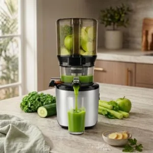 Kuvings AUTO10 cold press juicer in silver on a modern kitchen counter, producing fresh green juice hands-free