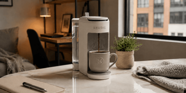 Keurig K-Mini Mate Plus compact single serve coffee maker brewing on a small kitchen counter in morning light